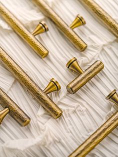 several gold colored wooden handles and knobs on white fabric