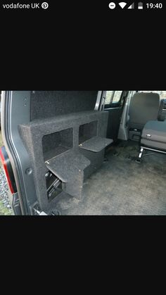 the back end of a van with its seats folded down and stairs up to it