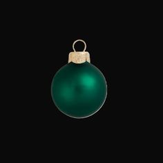 a green ornament hanging on a black background