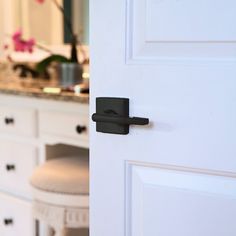 an open door with a handle on it in front of a bathroom sink and mirror