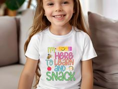 The "I'm Here to Learn and Snack" Tshirt is perfect for kids heading back to school! This fun and cool shirt is ideal for kindergarteners, making the first day of school extra special. 👉 Unisex T-shirt - 100% Airlume combed and ringspun cotton  - Soft cotton and quality print make users fall in love with it over and over again.  - These t-shirts have-ribbed knit collars to bolster shaping. - Printed and shipped from the USA CARE INSTRUCTIONS - Wash inside out with like colors. - Tumble dry or h Funny T-shirt For End Of School Year, Playful T-shirt For Daycare And Back To School, White Funny Text Shirt For School, Funny T-shirt For School, White Shirt With Funny Text For School, Back To School Funny Text T-shirt, Funny White School Shirt, Funny Text T-shirt For Back To School, Fun School Shirt With Funny Text