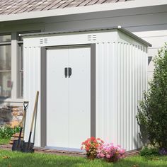 a white shed sitting on top of a lush green field