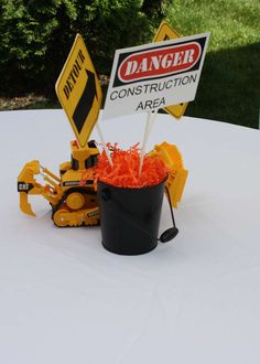 there is a construction area sign on top of a bucket filled with orange shredded carrots