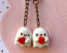 two little ghost keychains with hearts on them