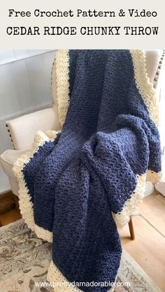 a blue crochet blanket sitting on top of a chair next to a white chair