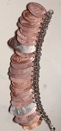 a bunch of coins that are sitting on a table with a chain around it's neck