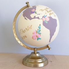 a globe with flowers on it sitting on a table