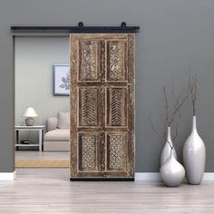 a living room with two vases and a wooden door