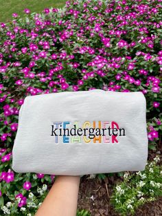 someone holding up a white bag with the word kindergarten on it