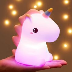 a hand holding a small light that looks like a unicorn