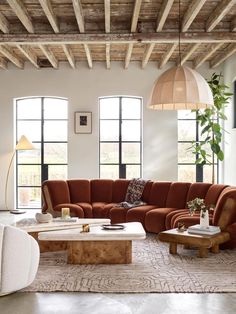 a living room filled with lots of furniture next to tall windows and large windows on the wall