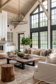 a living room filled with lots of furniture next to large windows and a fire place