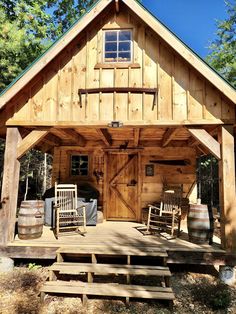 a wooden cabin with two rocking chairs on the porch