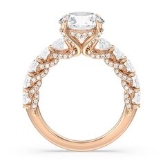 a rose gold engagement ring with an oval center stone and side stones on the band