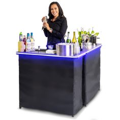 a woman standing behind a bar with bottles on it