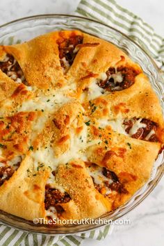 a cheesy pizza in a glass pie dish