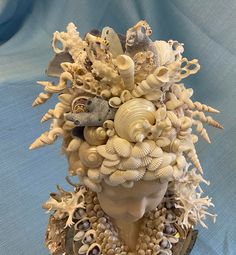 there is a sculpture made out of sea shells and other things on top of it