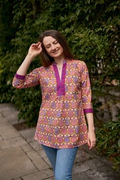 🌷 ANANDA Add a splash of colour to your wardrobe with our Ananda Tunic in vibrating floral prints. Ananda was created for a comfortable loose fit, and decorated with floral hand block prints. Sizings: Size S:   Shoulders 38cm - 14.9" Bust  96cm - 37.7" Length approx. 71cm - 29.5" Size M:   Shoulders 40cm - 15.7" Bust  100cm - 40" Length approx. 75cm - 29.5" Size L:   Shoulders 44cm - 17.3" Bust  106cm - 42" Length approx. 75cm - 29.5" Materials: Fabric: 100% Hand Block Printed Cotton  Care Inst Summer Split Neck Pink Blouse, Pink Bohemian Relaxed Fit Blouse, Hippie Pink V-neck Tops, Casual Multicolor Block Print Blouse, Purple Cotton V-neck Blouse, Beach Purple Printed Blouse, Bohemian Cotton Top With Split Neck, Pink Bohemian Cotton Top, Bohemian Pink Long Sleeve Tunic