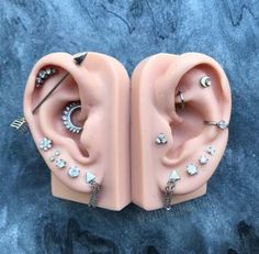 two fake ear pieces with piercings on them