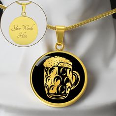 a black and gold necklace with a beer mug on it's front, next to a white mannequin