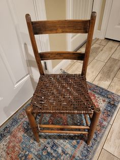 a wooden chair sitting on top of a rug