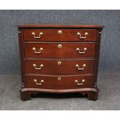 an antique chest of drawers with brass handles