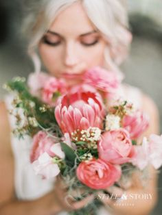 a woman holding a bouquet of flowers in her hands