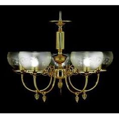 a gold chandelier with glass shades on the bottom and two lights above it