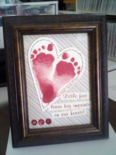 a picture frame with two footprints in the shape of a heart