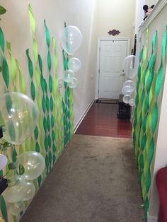 the hallway is decorated with green and white streamers, balloons, and other decorations