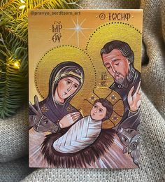 a christmas card with an image of the virgin mary and baby jesus on it next to a tree