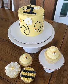 a cake and cupcakes on a wooden table