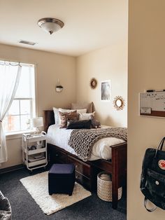 a bed room with a neatly made bed and a bag on the floor next to it