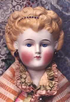 an old doll with blonde hair and blue eyes