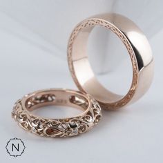 two gold wedding rings sitting next to each other