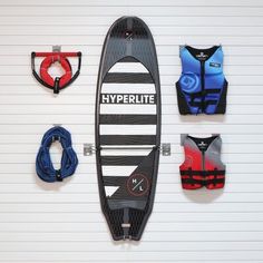 a surfboard mounted to the side of a wall with life vests on it