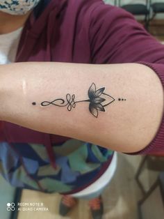 a woman's arm with a flower tattoo on the left side of her arm