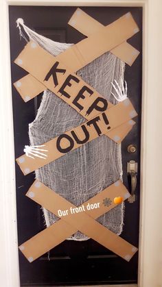 a door decorated with cardboard tape and some words that say keep out on the front door