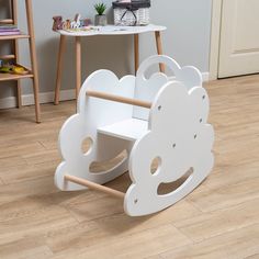 a child's wooden rocking chair with clouds painted on the front and back sides