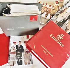 an assortment of personal items are displayed on a bed with white sheets and red covers