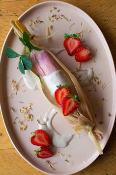 a white plate topped with strawberries on top of a wooden table