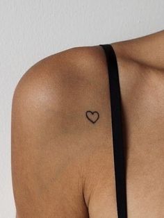 a woman with a heart tattoo on her shoulder