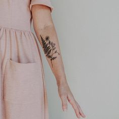 a woman's arm with a flower tattoo on the left side of her arm