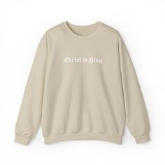 a beige sweatshirt with white writing that says christ is king on the front and back