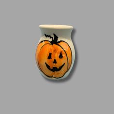 a white vase with a pumpkin painted on it