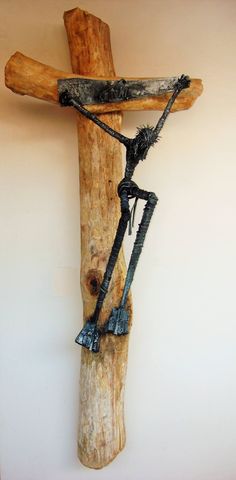 a wooden cross hanging on the side of a wall