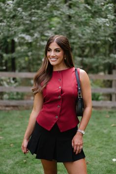 The Nova Vest-Burgundy is the perfect addition to any wardrobe. With its sleek burgundy color, adjustable strap on the back, and button down closure, this vest top is both stylish and functional. Expertly crafted, this vest top offers a sophisticated and polished look for any occasion! 95% polyester, 5% spandex Model is 5'3" with a 32" bust, 25" waist, and 38" hips and wearing a size small. Classic Red Vest For Workwear, Classic Red Sleeveless Vest, Sleeveless Workwear Top With Back Button Closure, Sleeveless Tops For Work With Back Button Closure, Elegant Sleeveless Top With Back Button Closure, Fitted Fall Tank Top With Button Closure, Elegant Tank Top For Fall, Fitted Tank Top With Button Closure For Fall, Workwear Tank Top With Button Closure For Fall