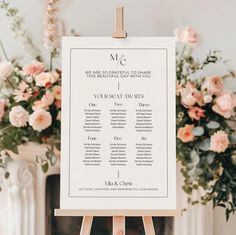 a wedding seating plan is displayed on a easel with flowers in the back ground