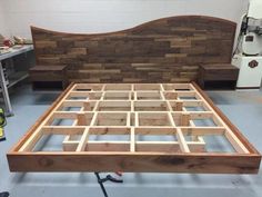 a bed frame made out of wood in a room