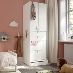 a child's bedroom with pink walls and white furniture